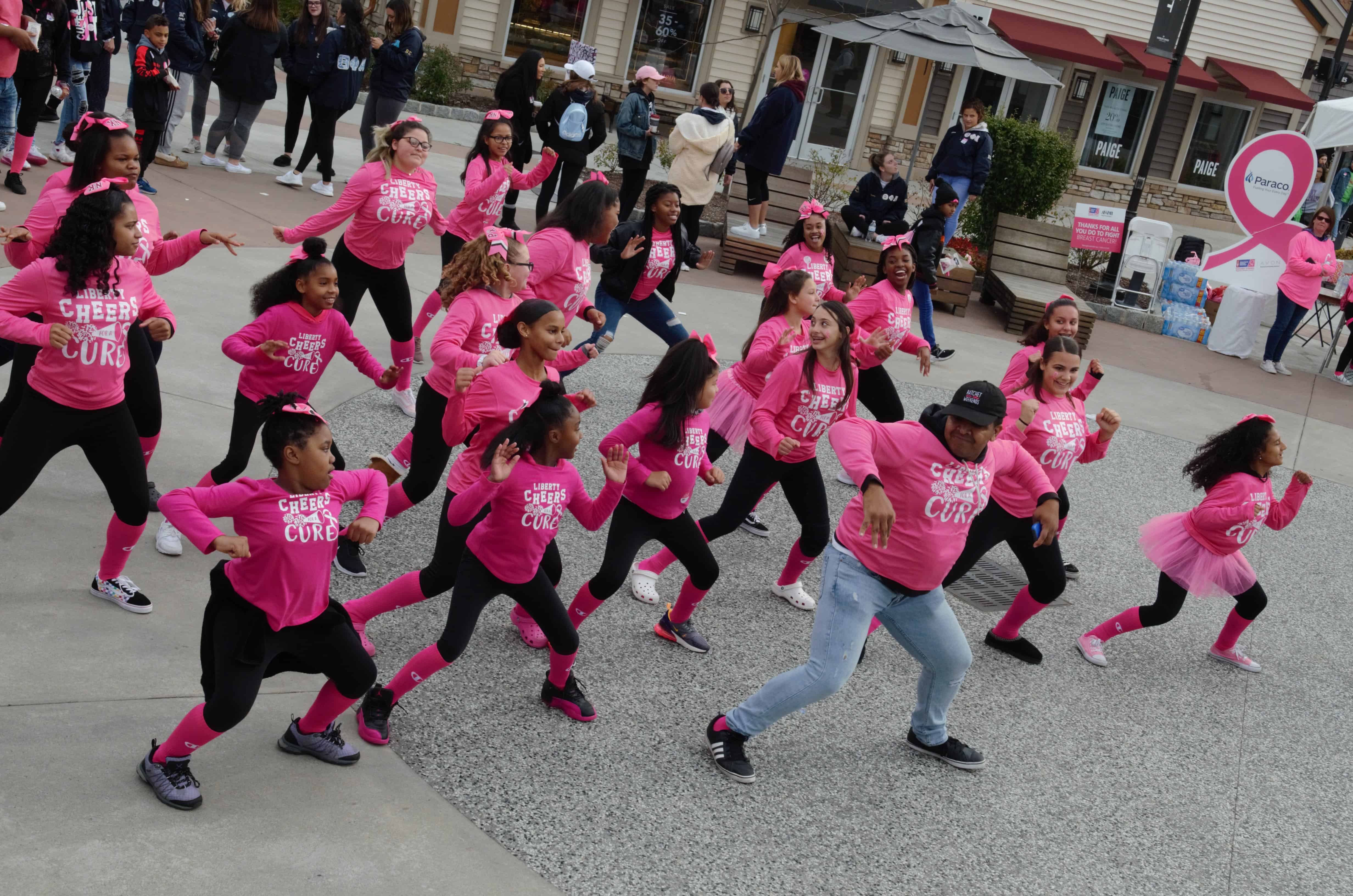 Women dancing and wearing pink shirts for breast cancer awareness